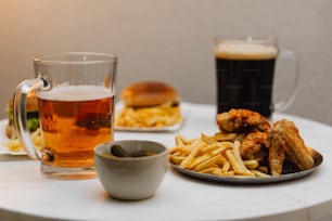 ein Tisch mit einem Teller Essen und einer Tasse Bier