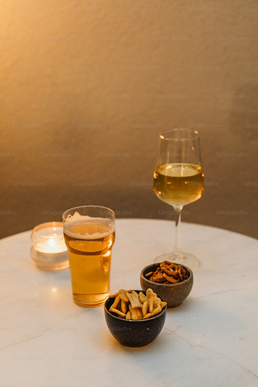 a glass of wine and a bowl of crackers on a table