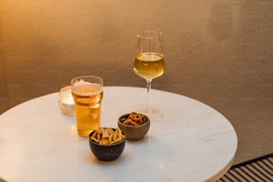 Zwei Gläser Wein und eine Schüssel Pommes auf einem Tisch