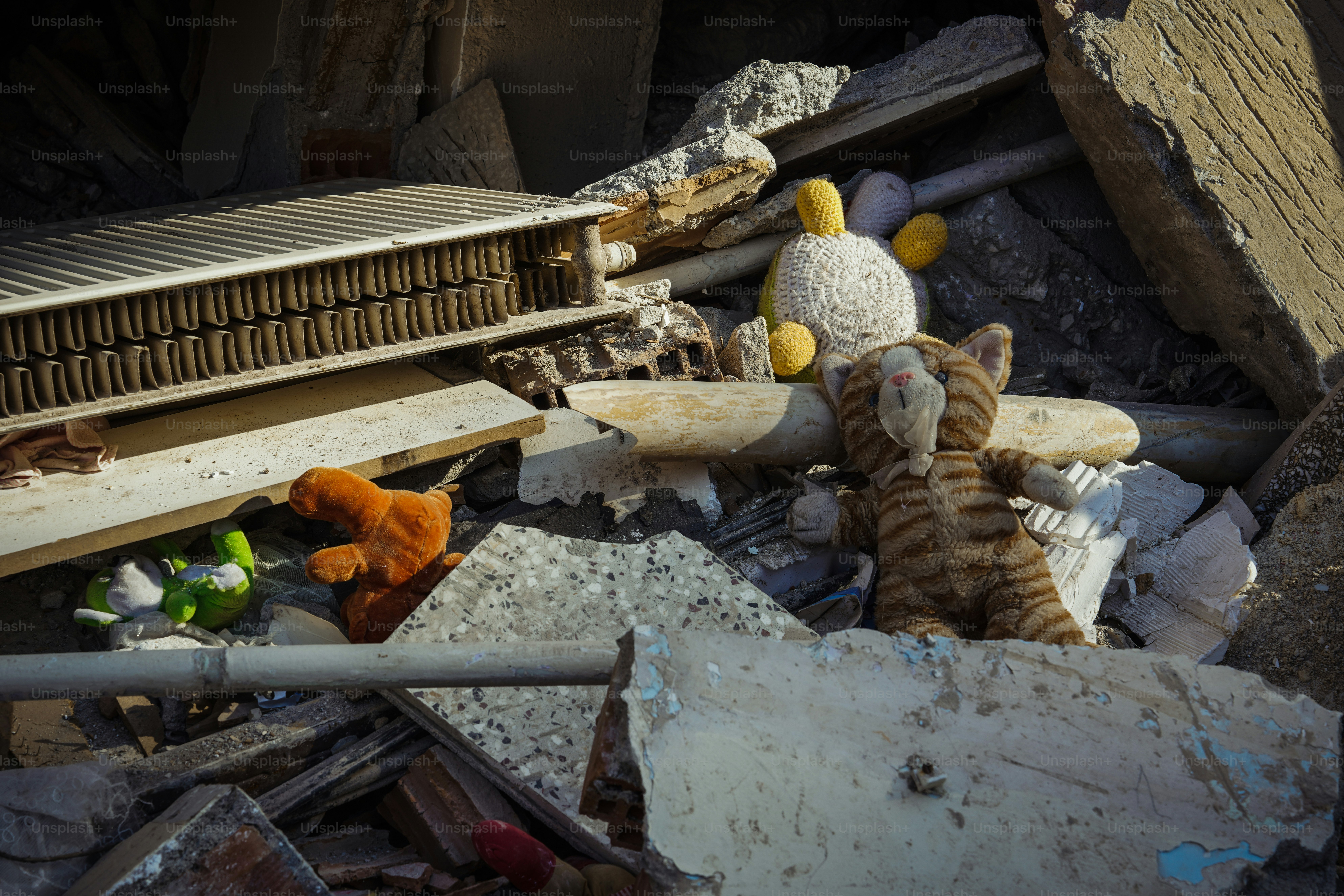 a cat stuffed animal sitting on top of a pile of rubble