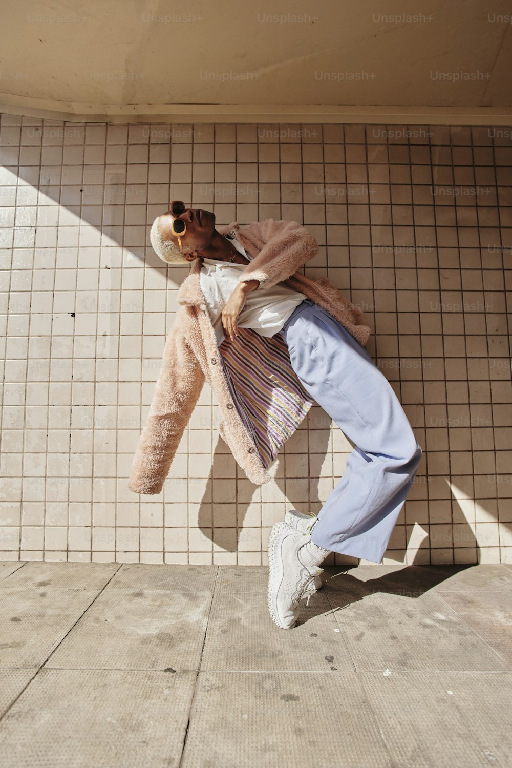 a person leaning against a wall with a teddy bear