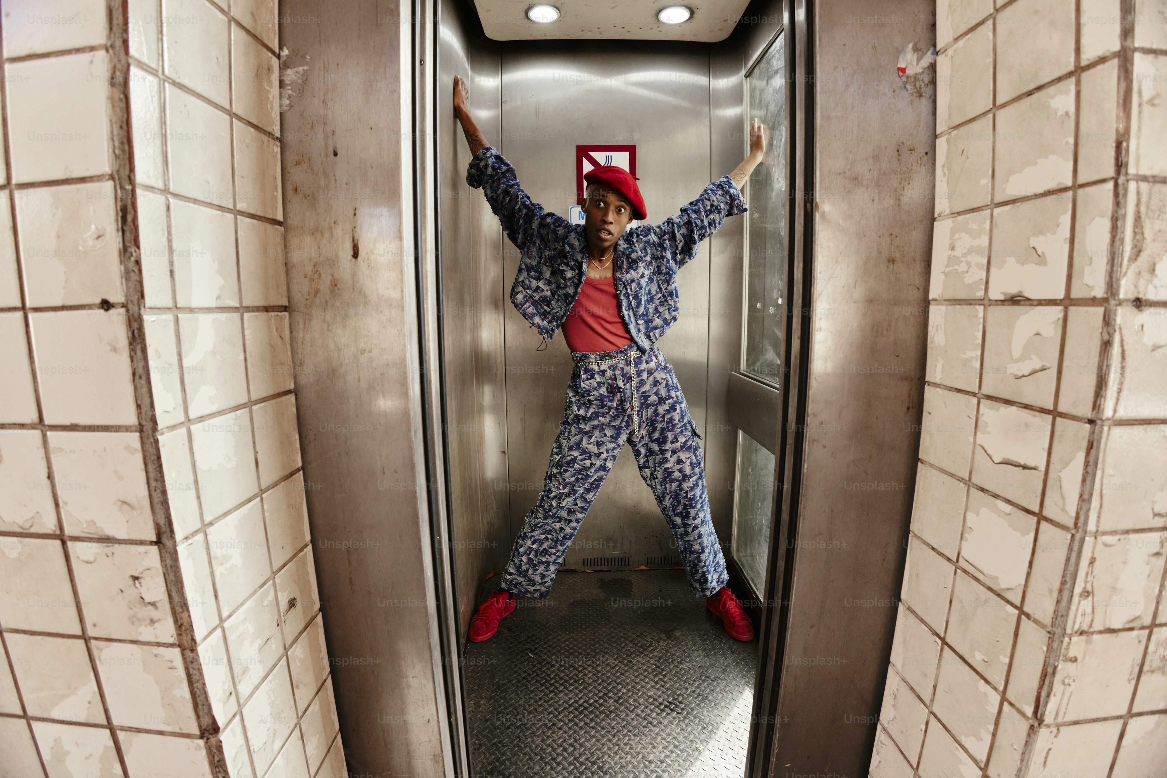 a man in pajamas and a red hat is standing on an escalator