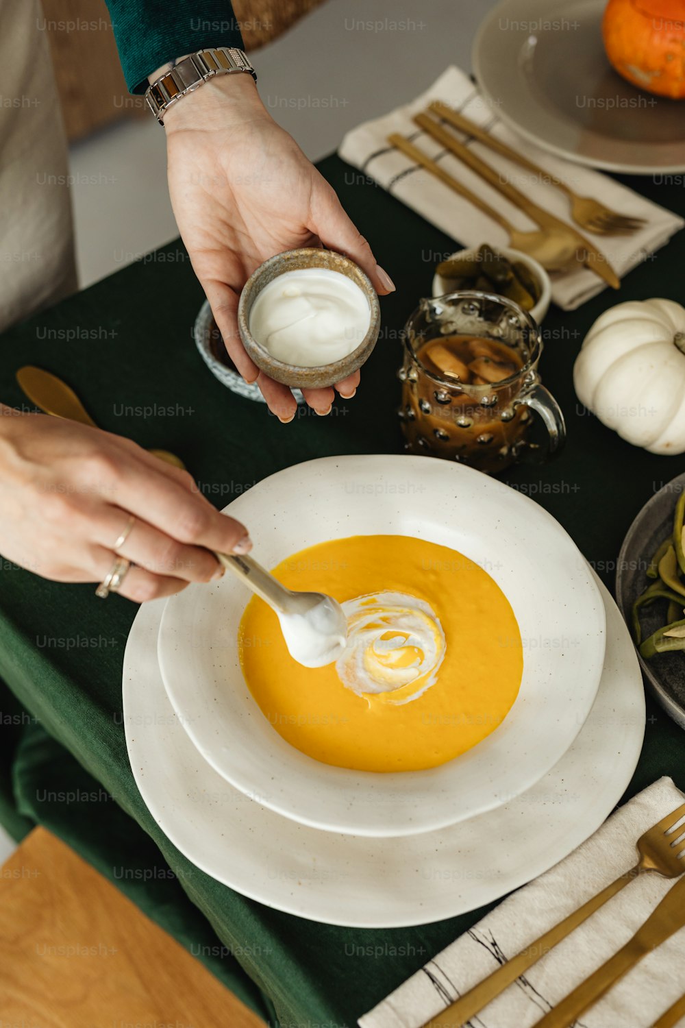 a person dipping a spoon into a bowl of soup