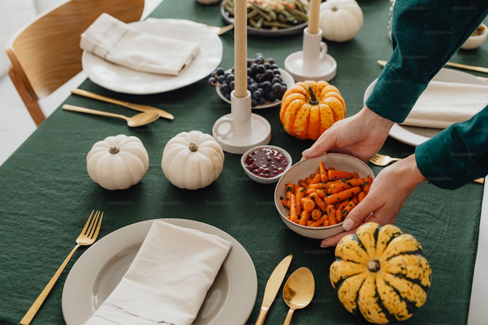 a table set for a thanksgiving dinner with pumpkins and gourds
