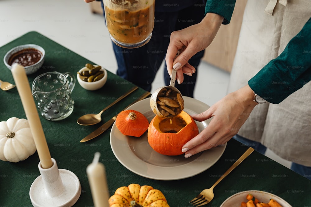 a woman is decorating a pumpkin on a table
