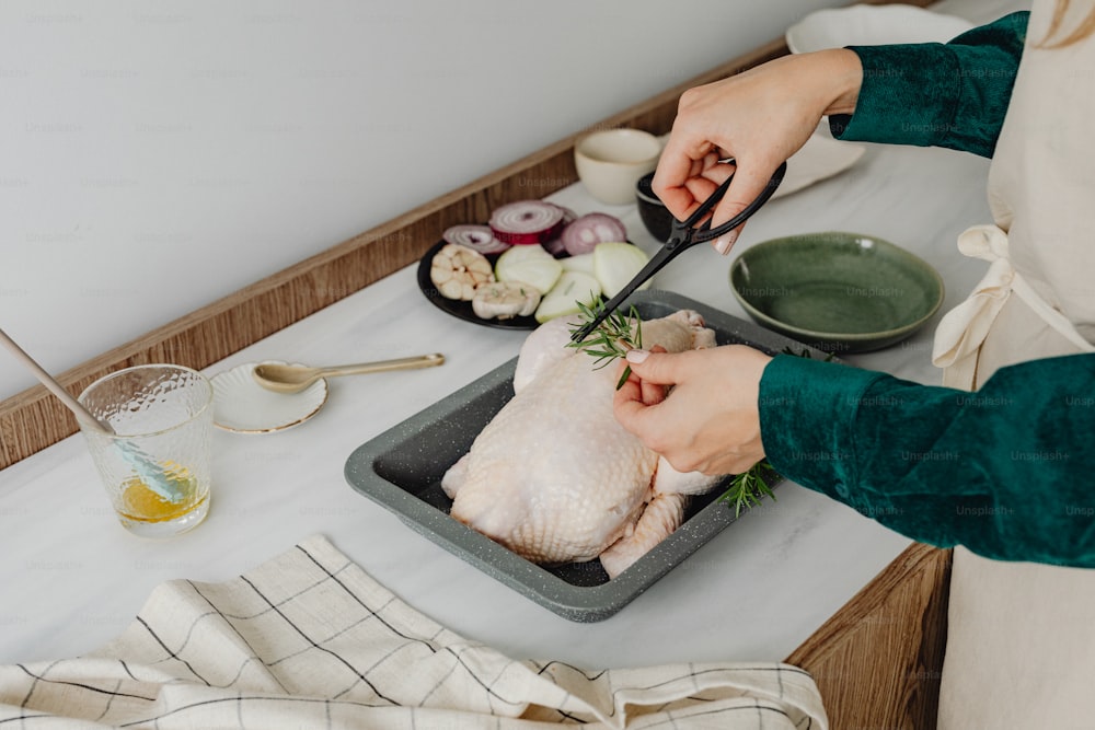 a person cutting a chicken on a cutting board