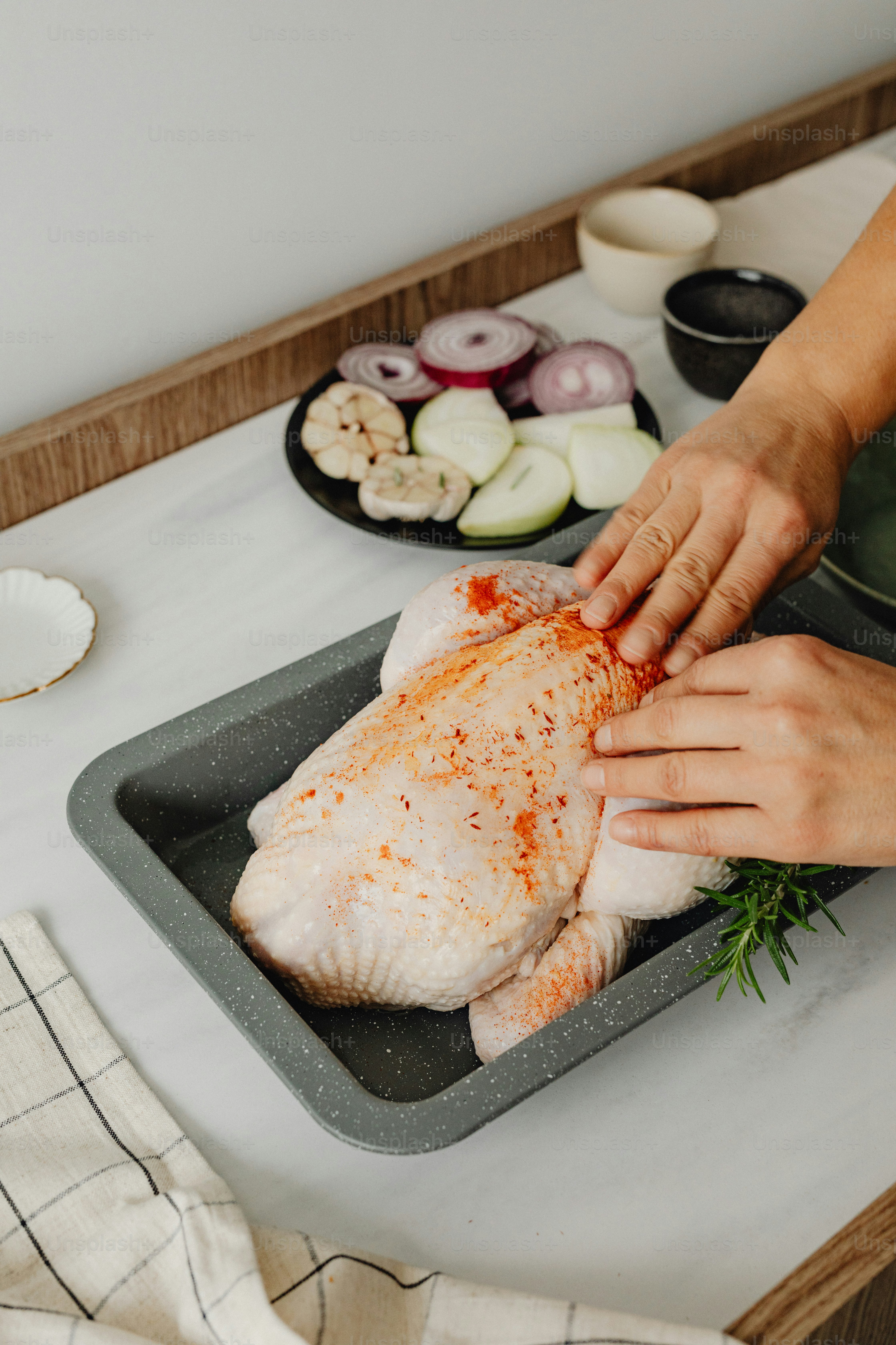 a person cutting up a piece of chicken on a counter