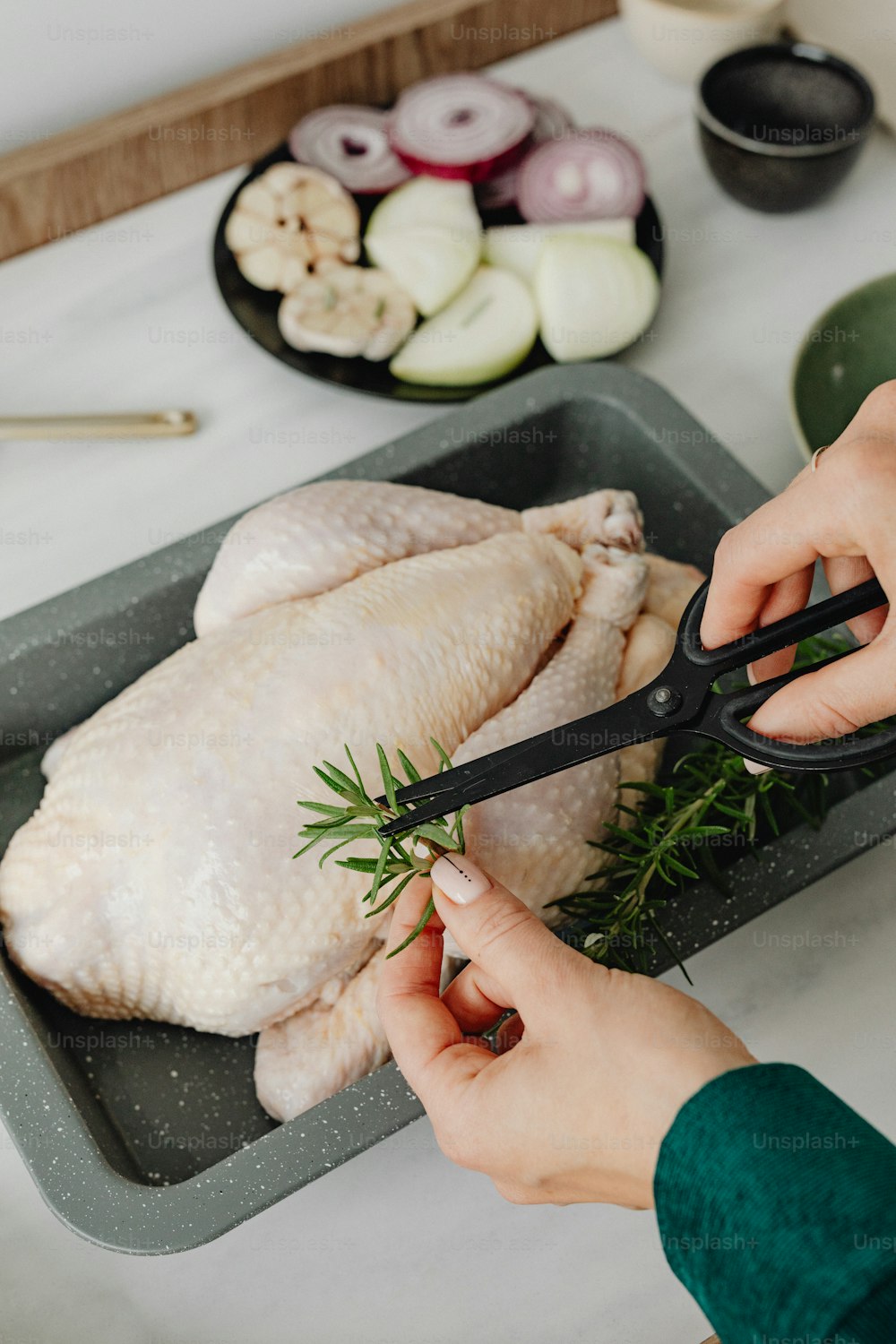 a person cutting a chicken with a pair of scissors