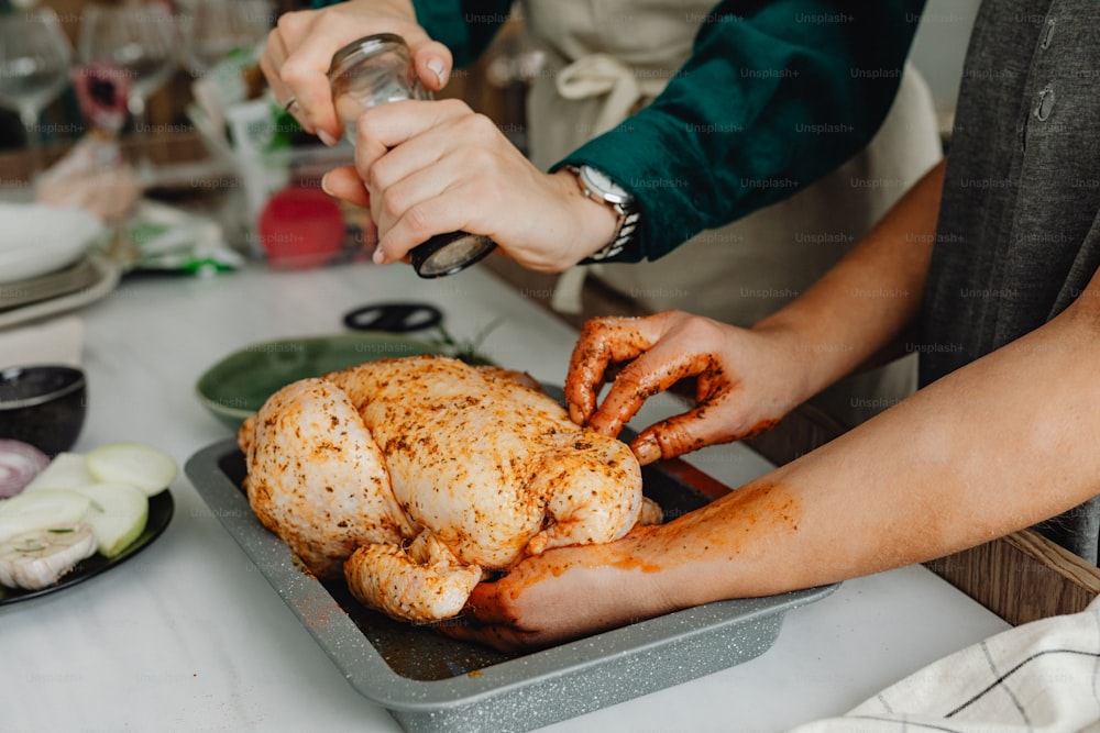 a person cutting up a whole chicken on a table
