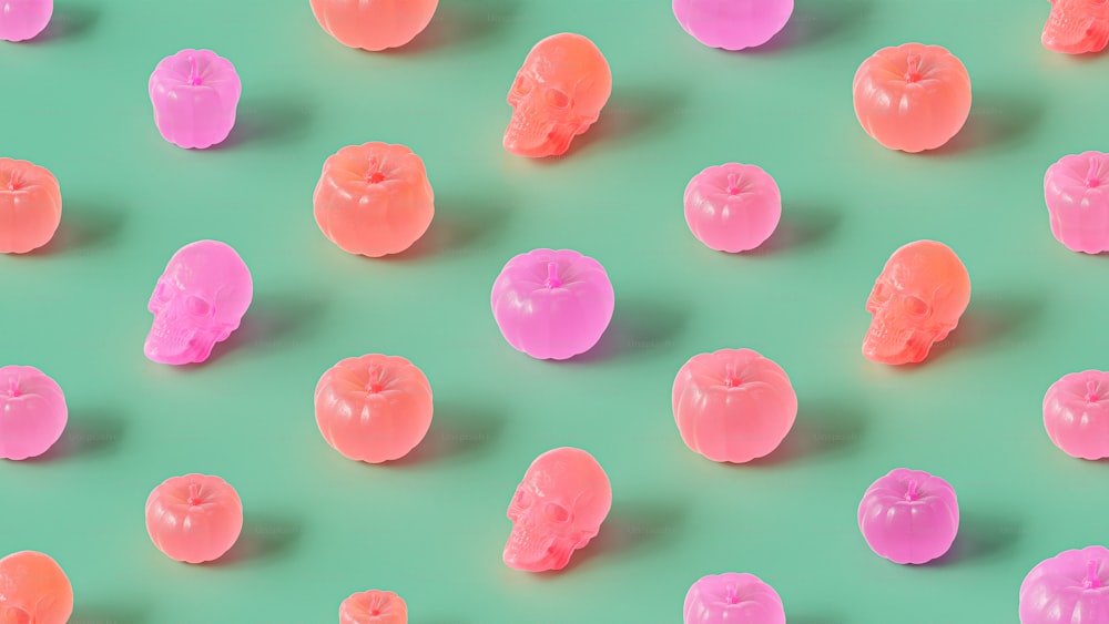 a group of pink and orange candies on a green background