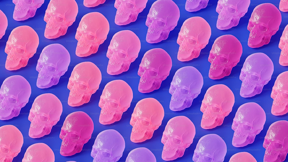 a group of plastic skulls sitting on top of a blue surface