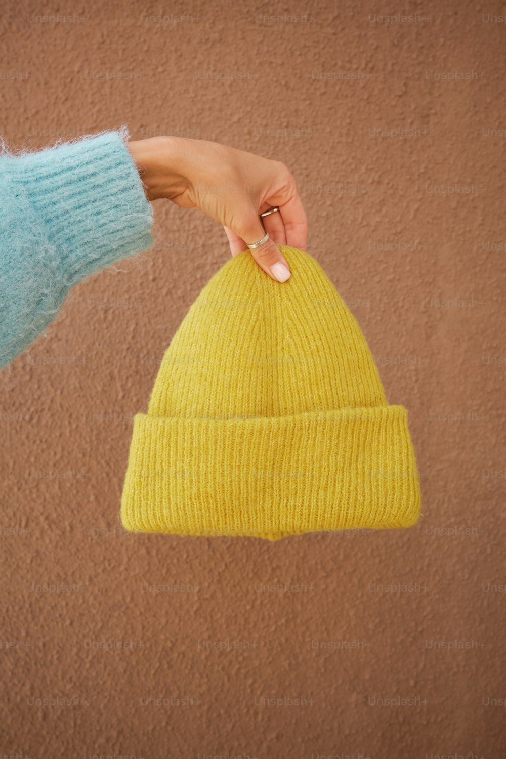 a person holding a yellow hat in their hand