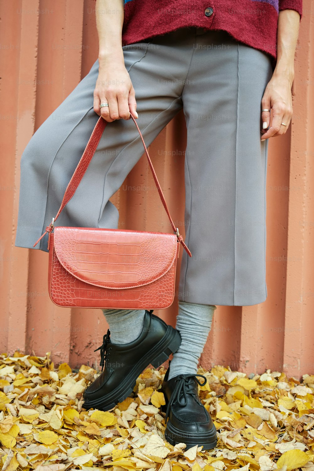 a woman is holding a pink purse in her hands