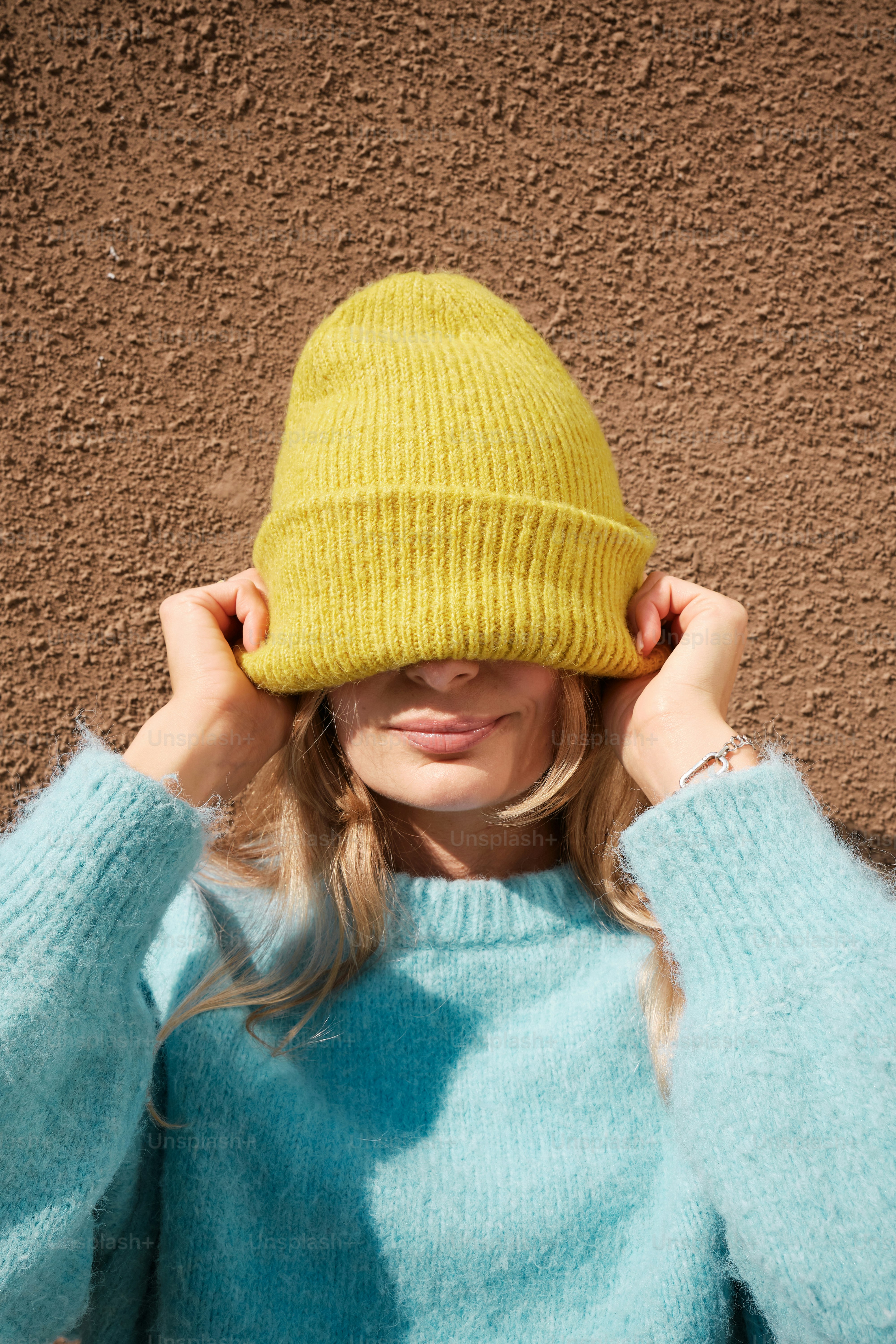 Eine Frau in einem blauen Pullover und einem gelben Hut