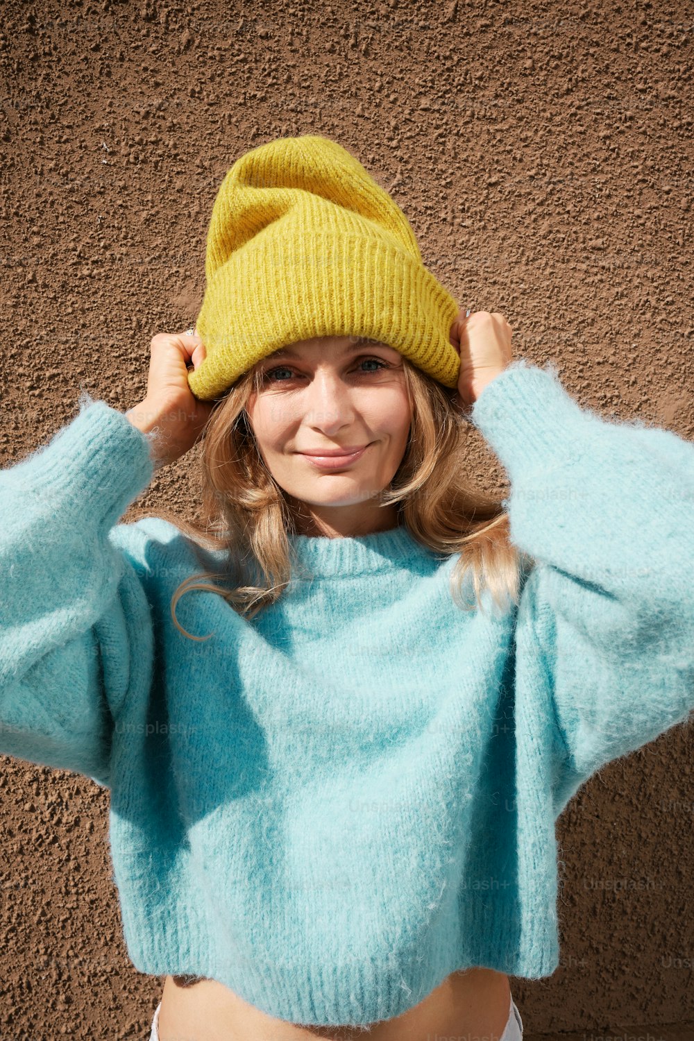 a woman wearing a blue sweater and a yellow hat