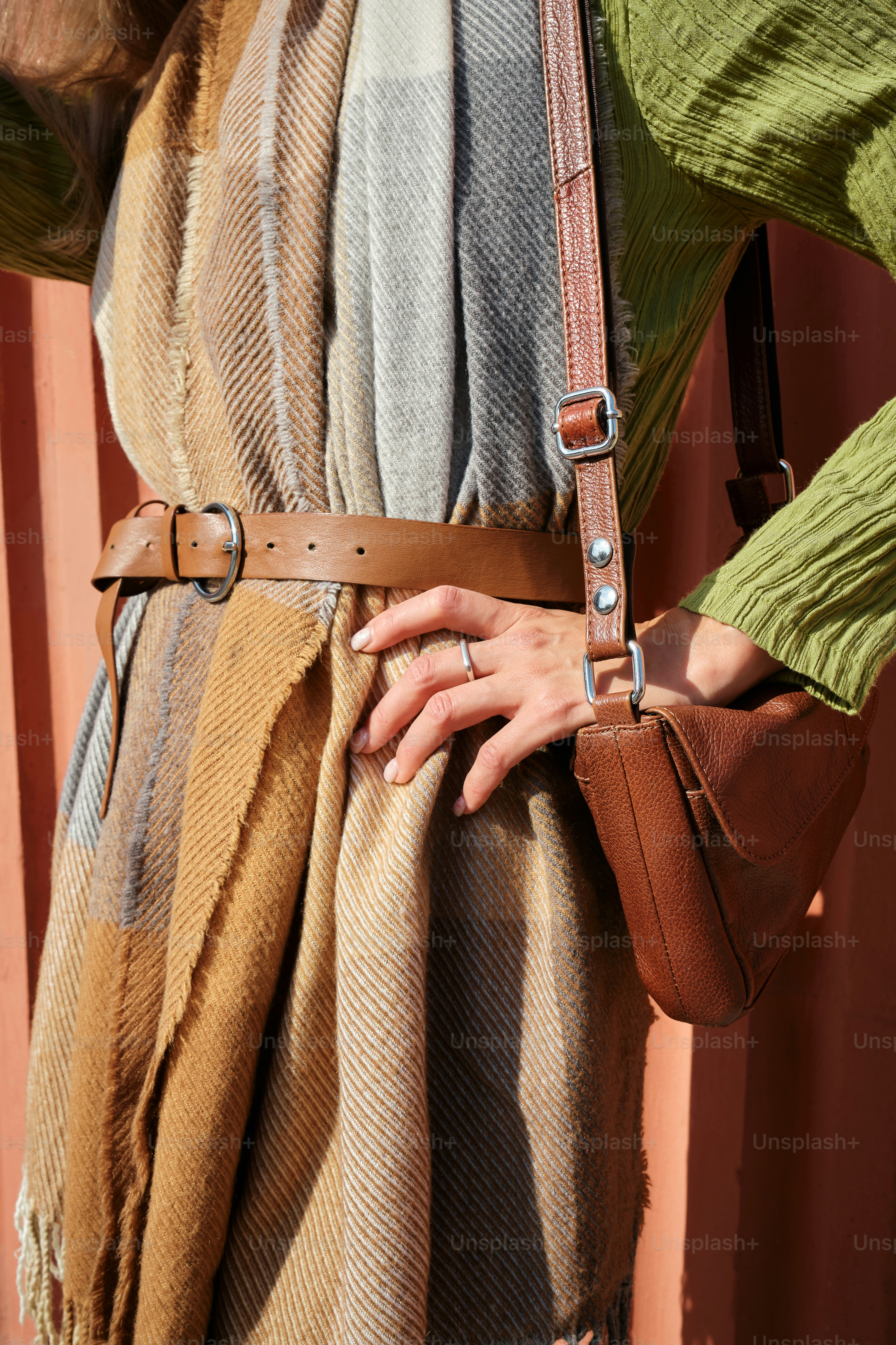 eine Frau mit braunem Gürtel und grünem Hemd