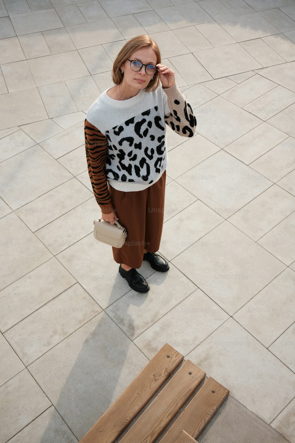 a woman wearing a leopard print sweater and brown pants