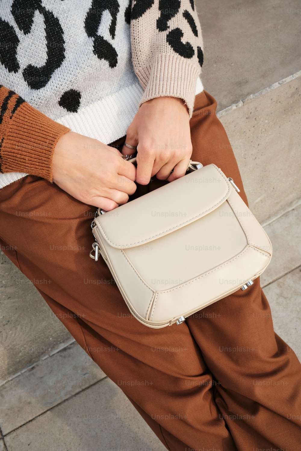 a woman holding a white purse on her lap