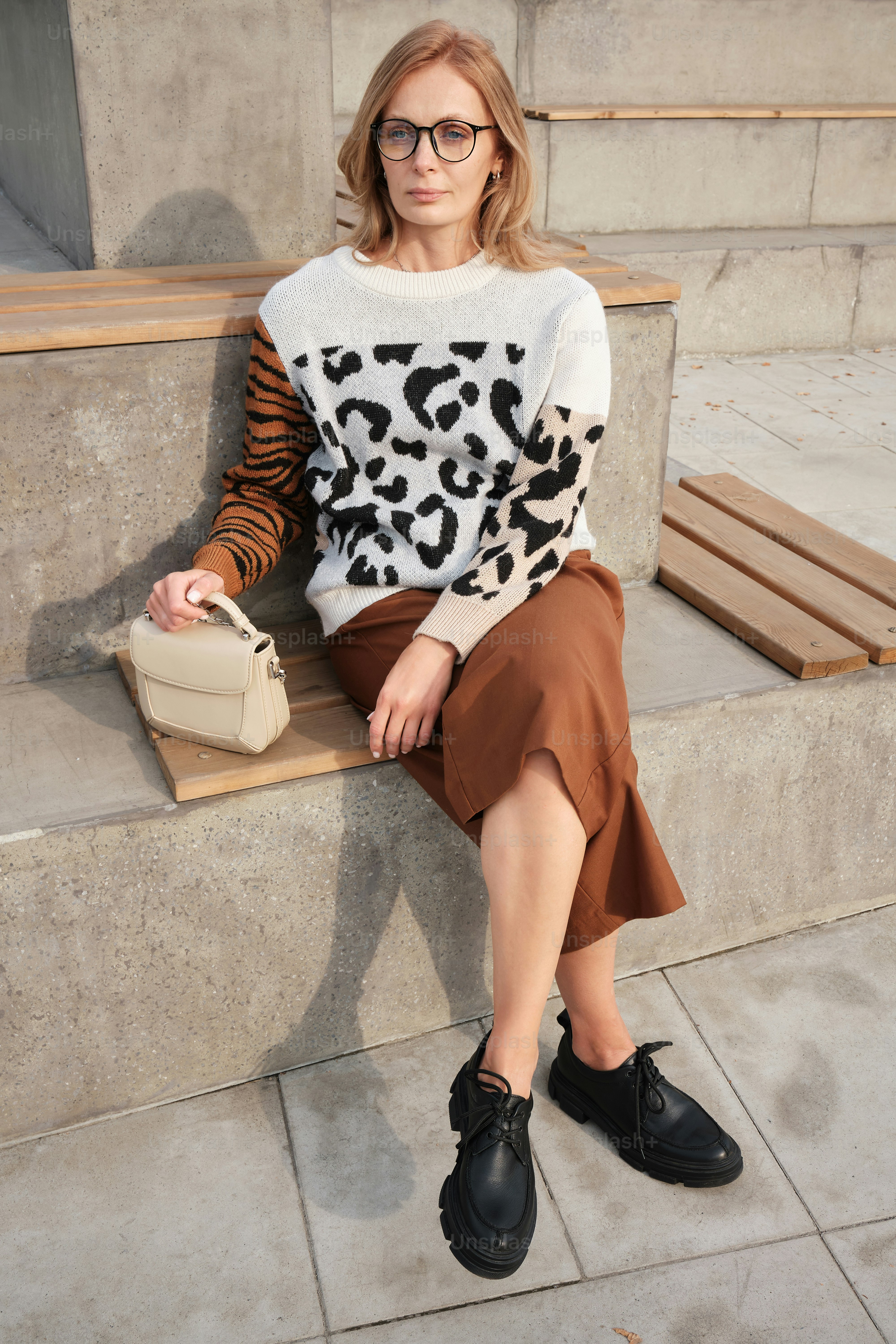 une femme assise sur un banc avec un sac à main
