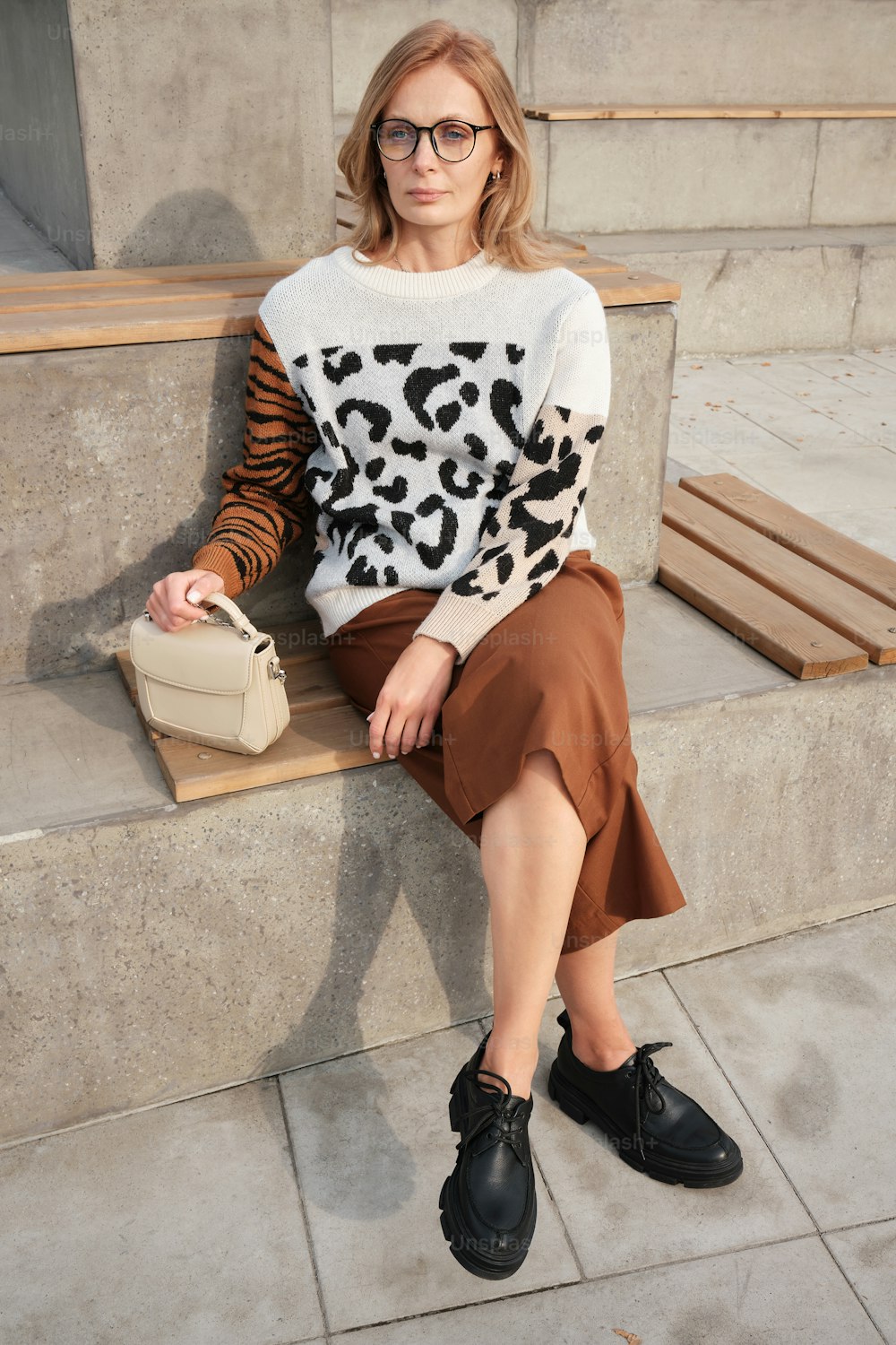 a woman sitting on a bench with a purse