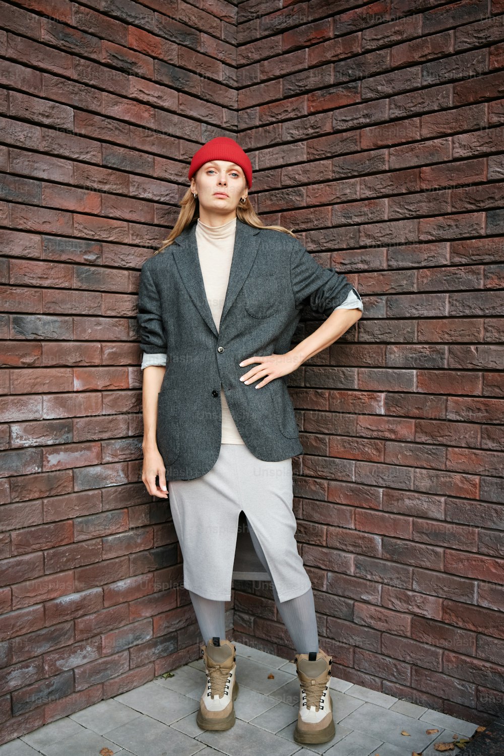 a woman standing in front of a brick wall