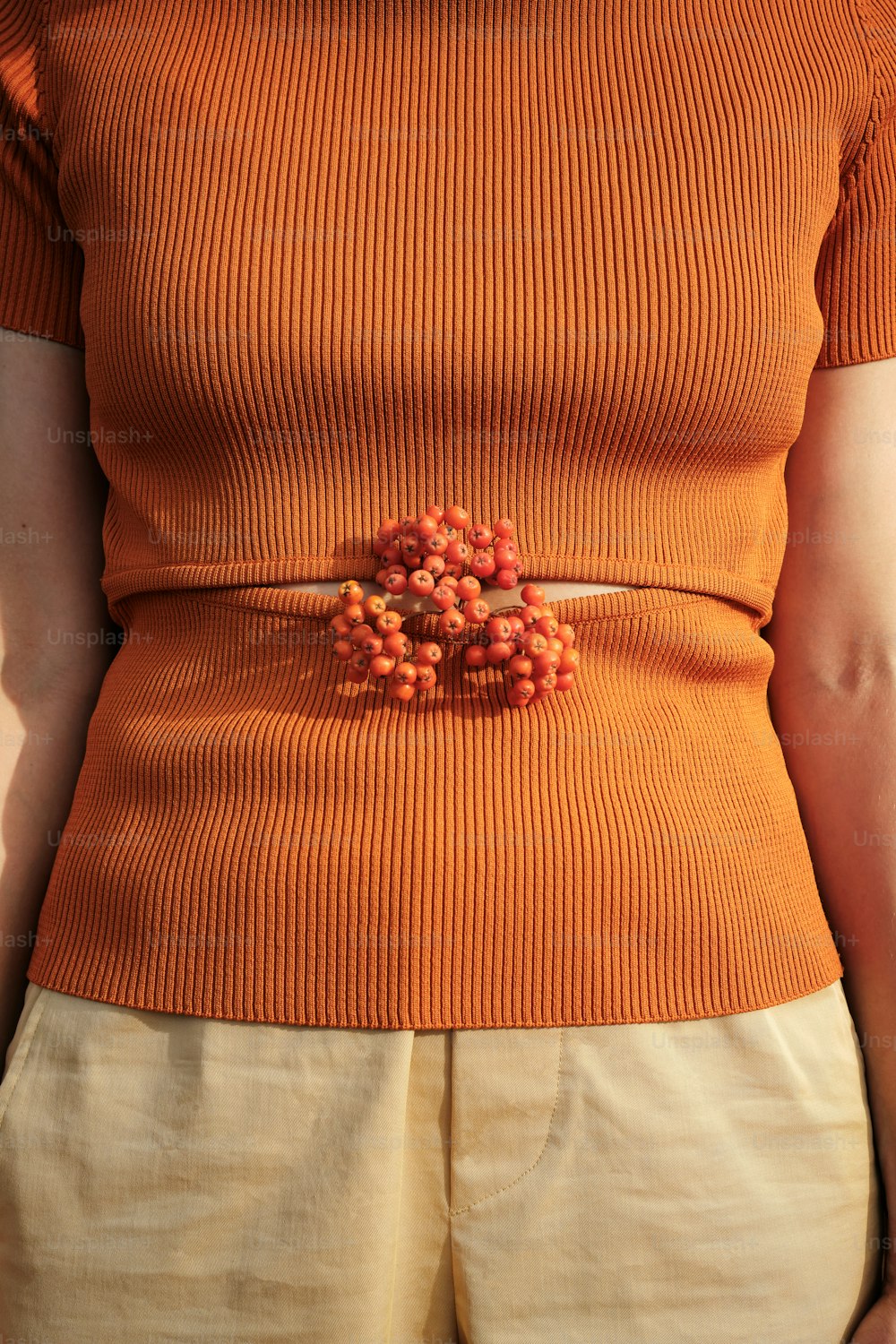 a woman wearing a belt with beads on it