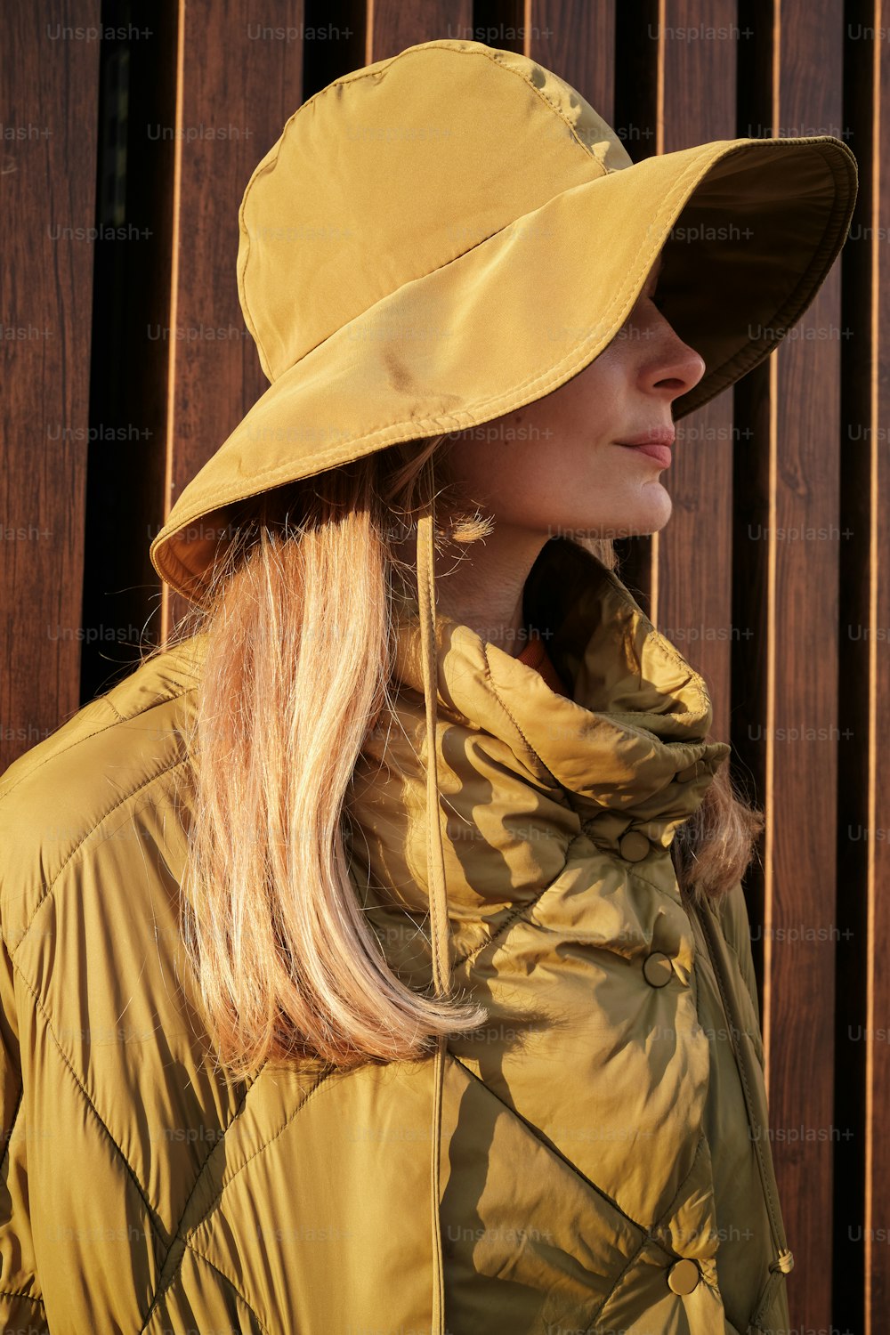 uma mulher usando um chapéu amarelo e jaqueta