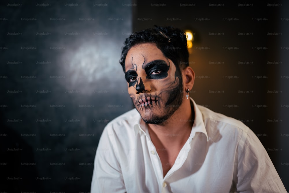 a man in a white shirt wearing a skeleton makeup