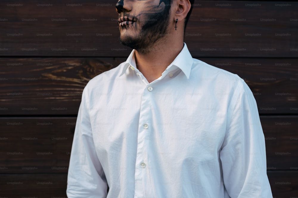 a man in a white shirt with black face paint