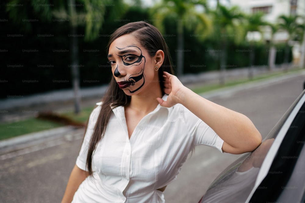 a woman in a white shirt and black face paint