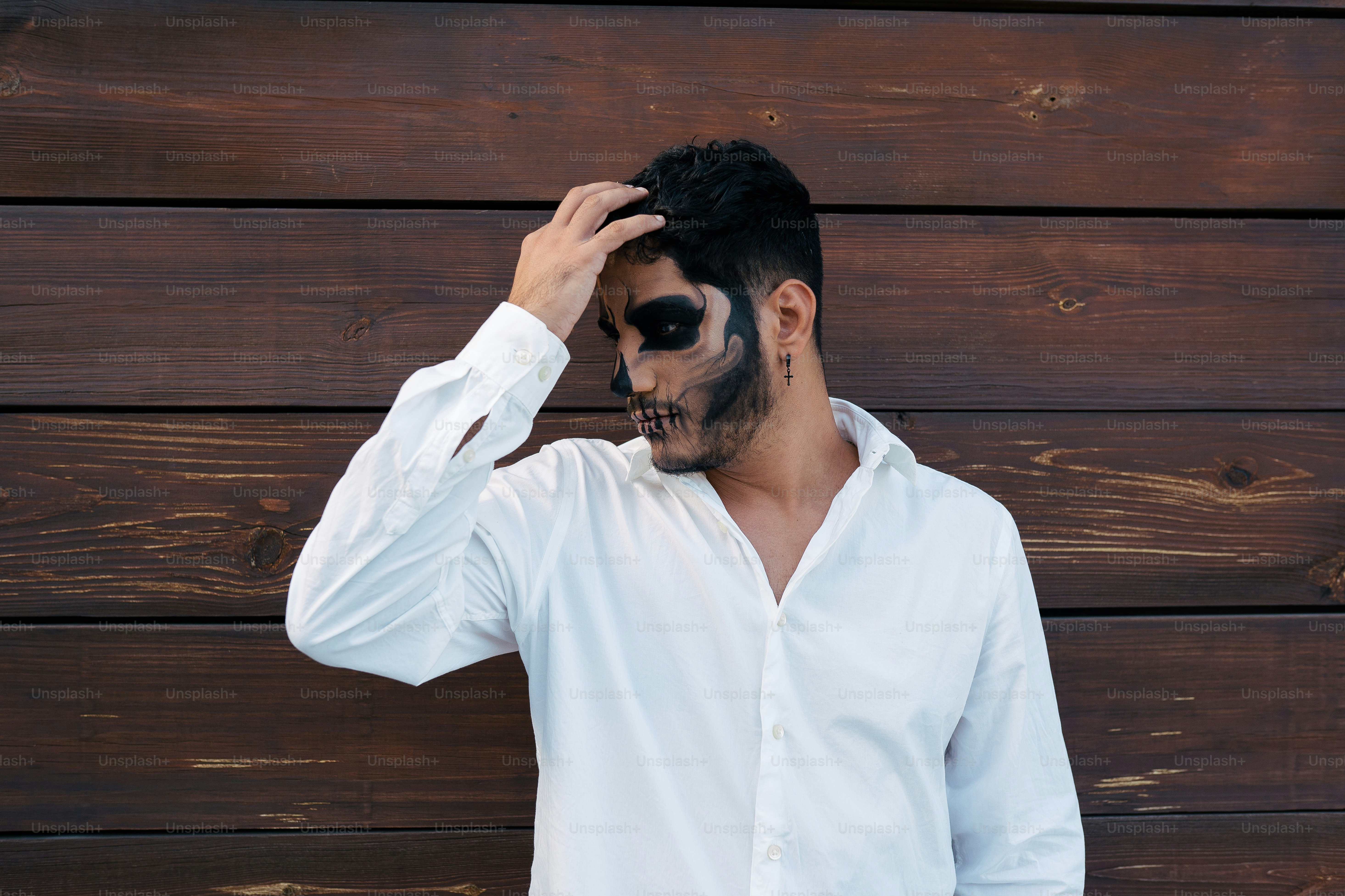 a man wearing a white shirt and black face paint