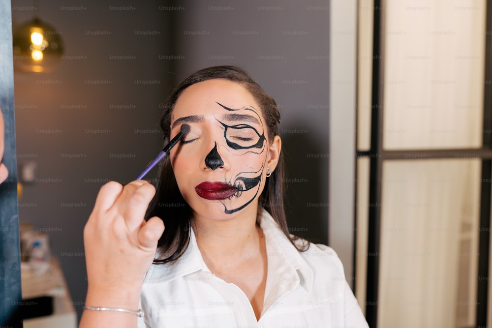 Una donna si sta facendo dipingere la faccia come un gatto