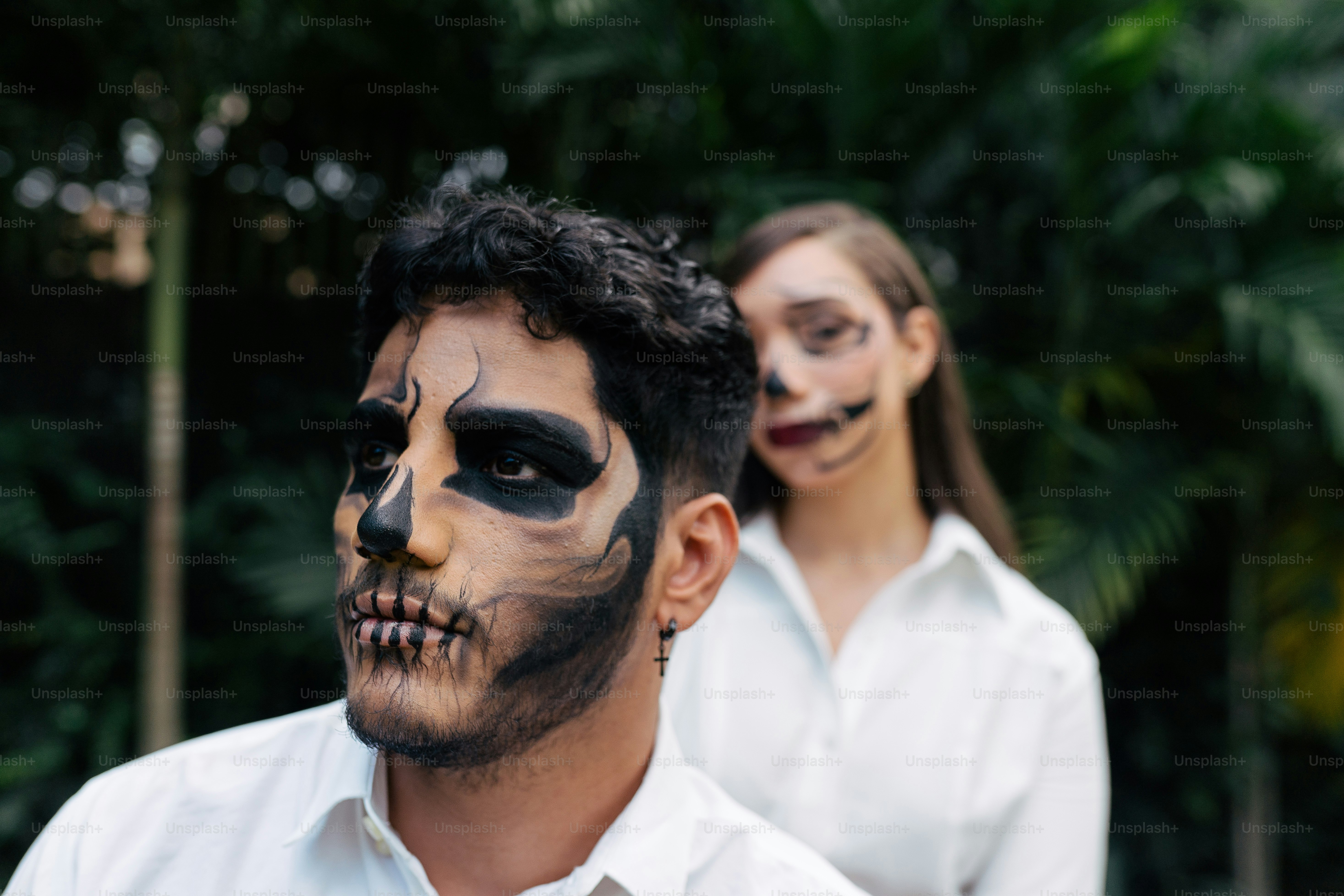 a man and a woman wearing face paint