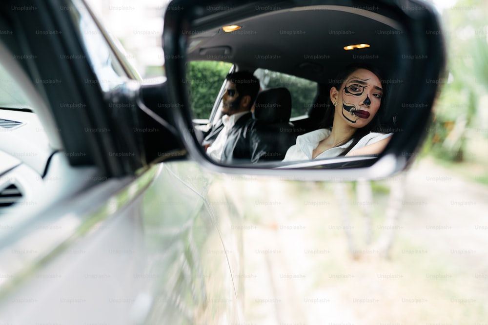 Una mujer en un coche con la cara pintada