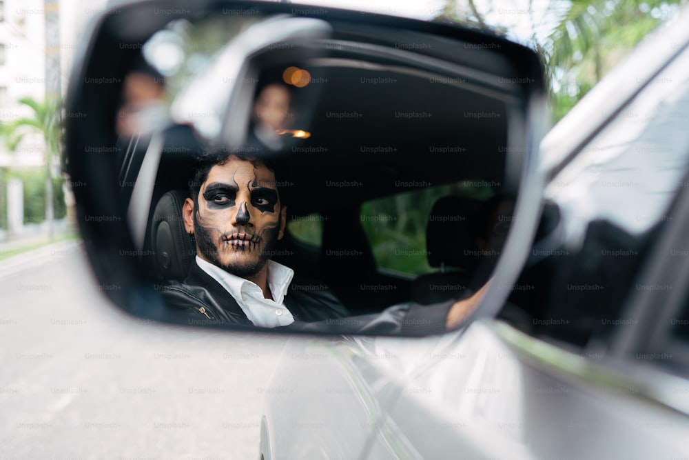 a man in a car with his face painted like a skeleton