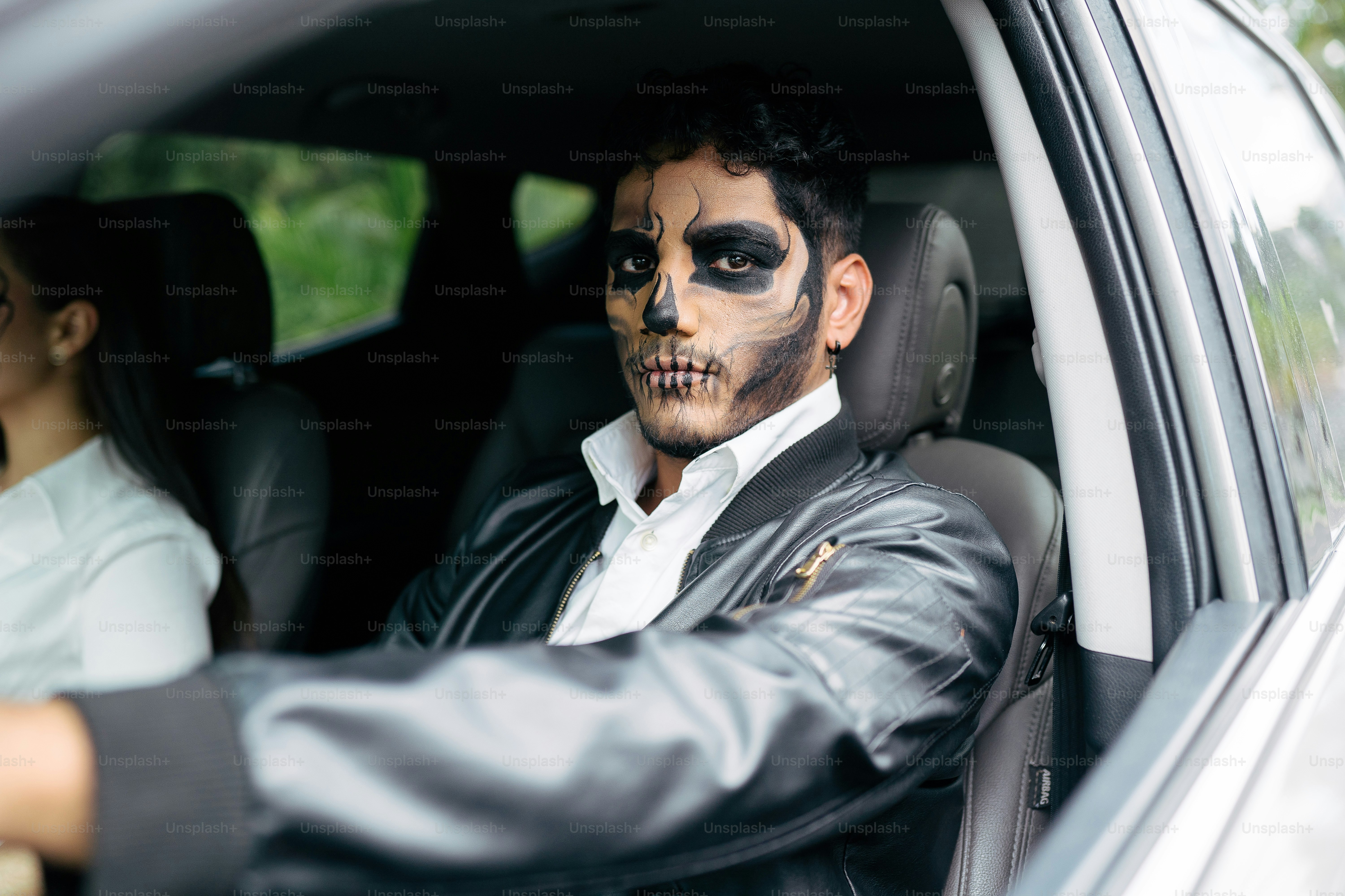 a man in a car with his face painted like a skeleton