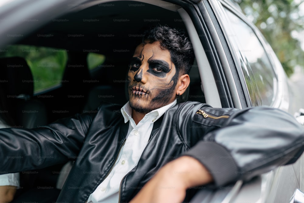 Un hombre con pintura facial sentado en un coche