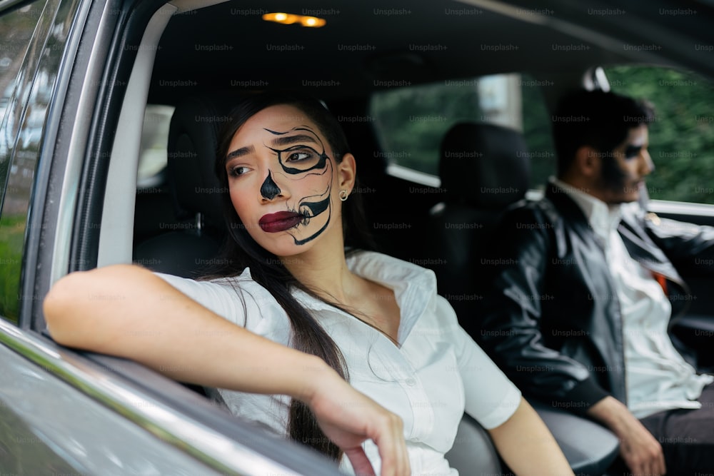 a woman sitting in the back seat of a car with a painted face