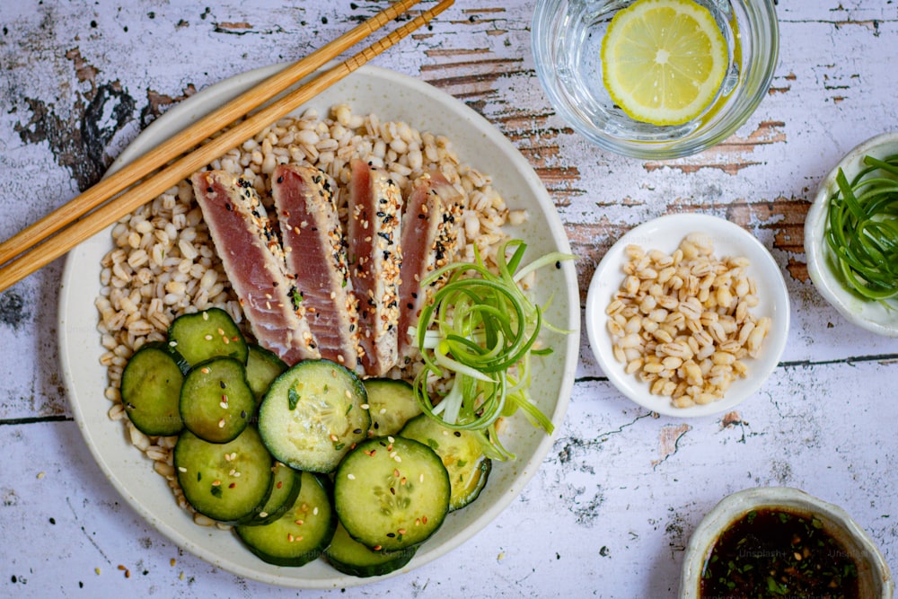 a white plate topped with cucumbers and tuna