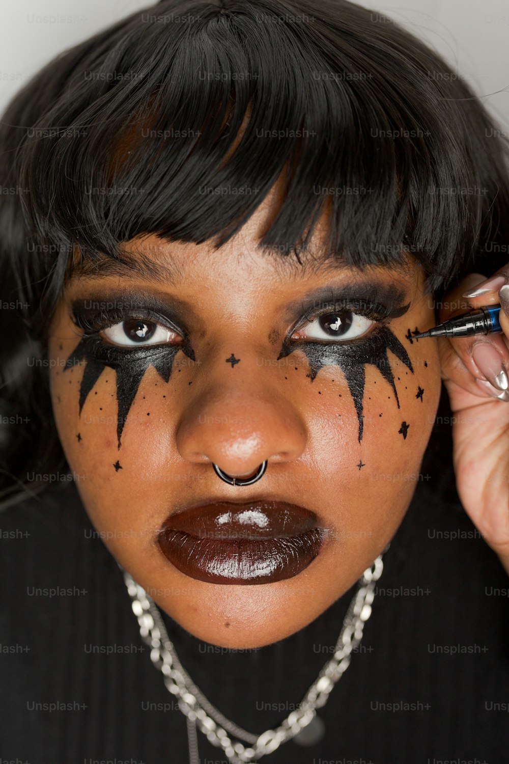 a woman with black makeup and a black cat face