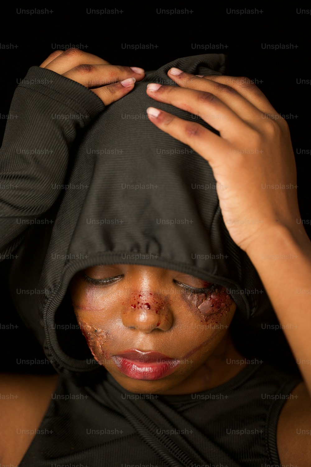 a woman with a black hoodie covering her face