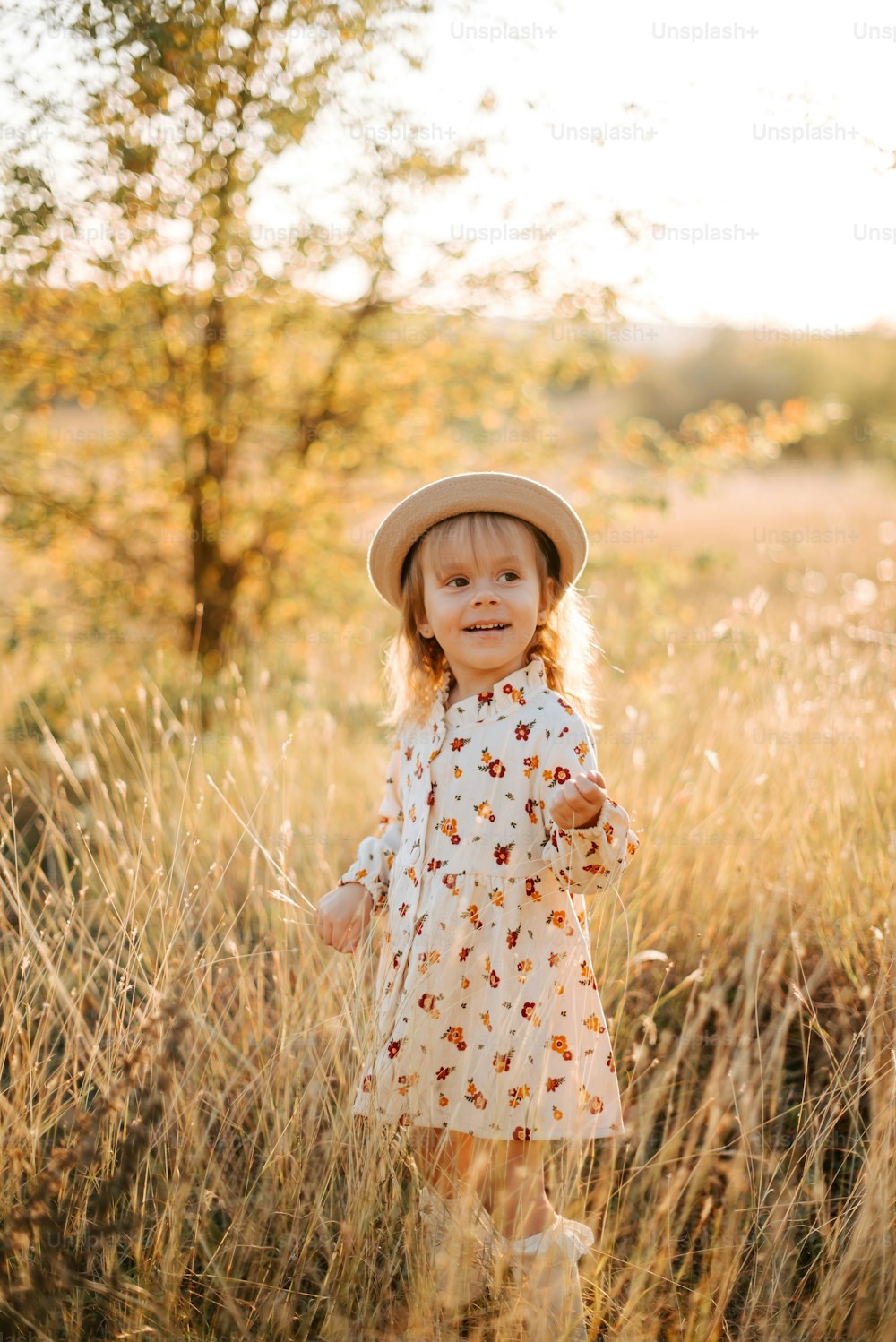 una bambina in piedi in un campo di erba alta