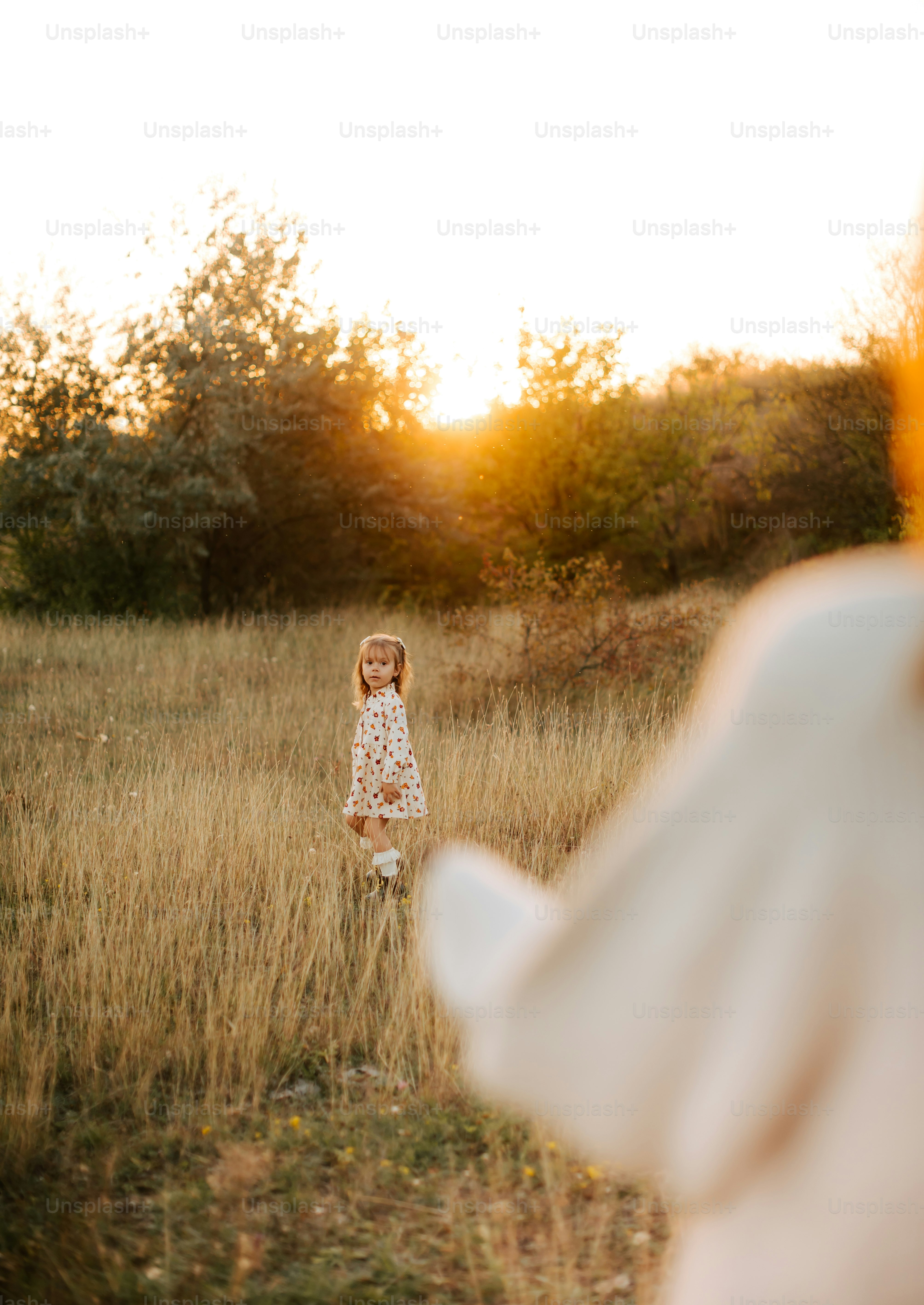 a woman in a white dress standing in a field