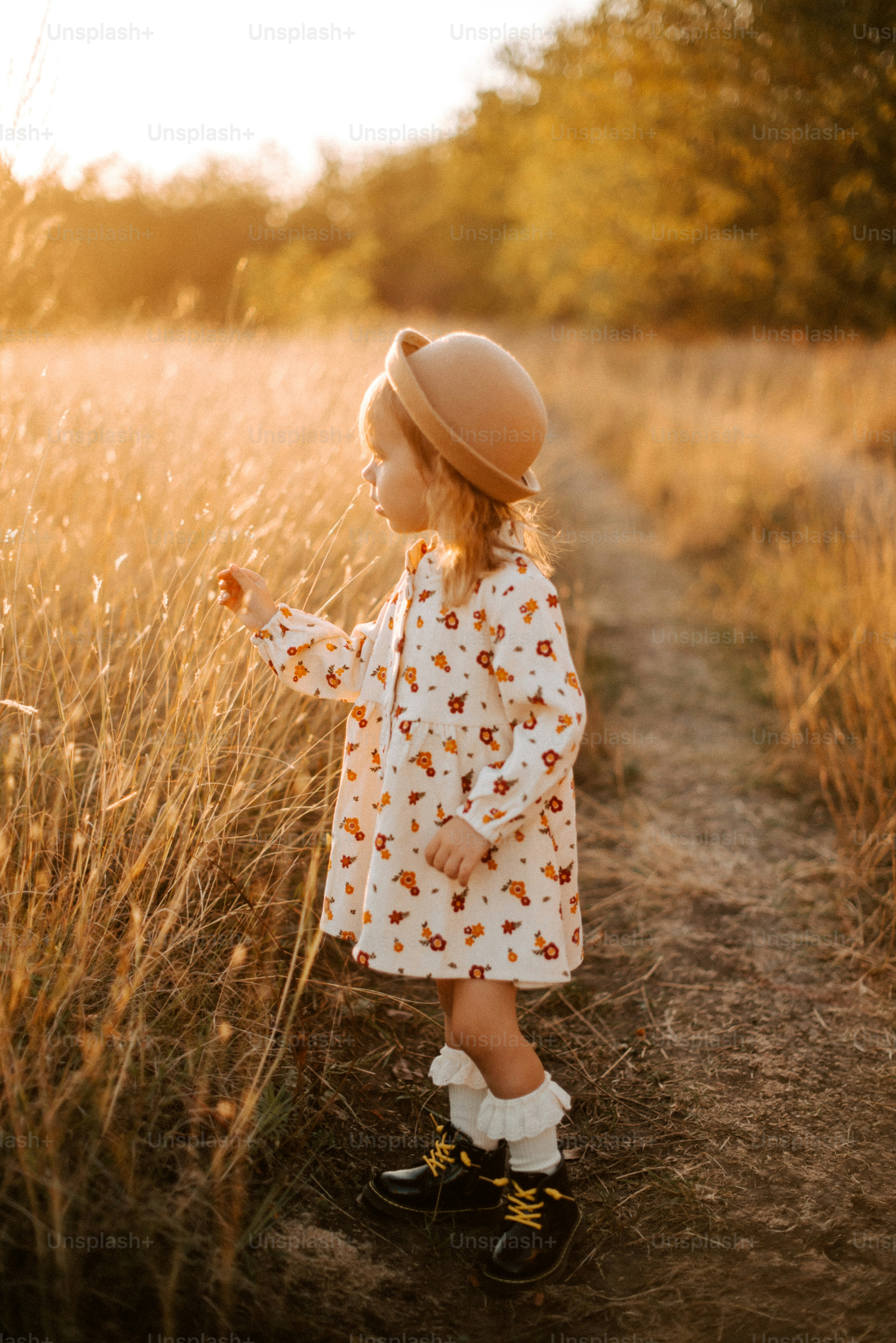 A little girl standing in a field of tall grass photo – Child Image on ...