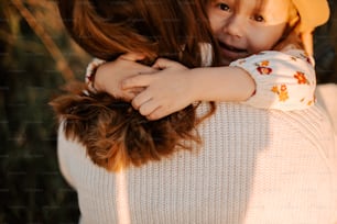 a little girl hugging her mother on the cheek
