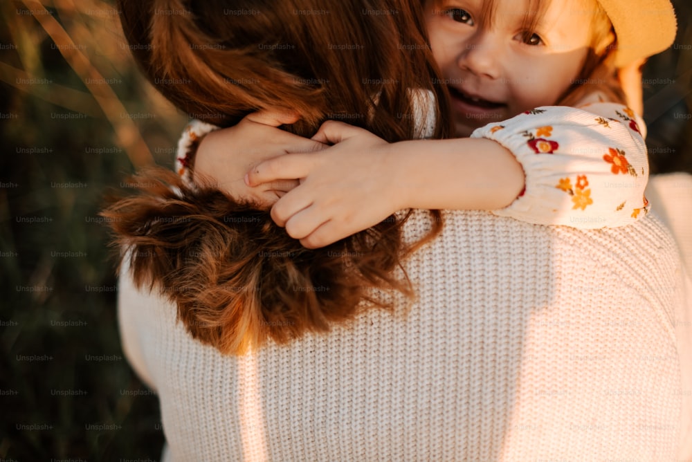 a little girl hugging her mother on the cheek