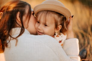 a little girl is kissing her mother on the cheek