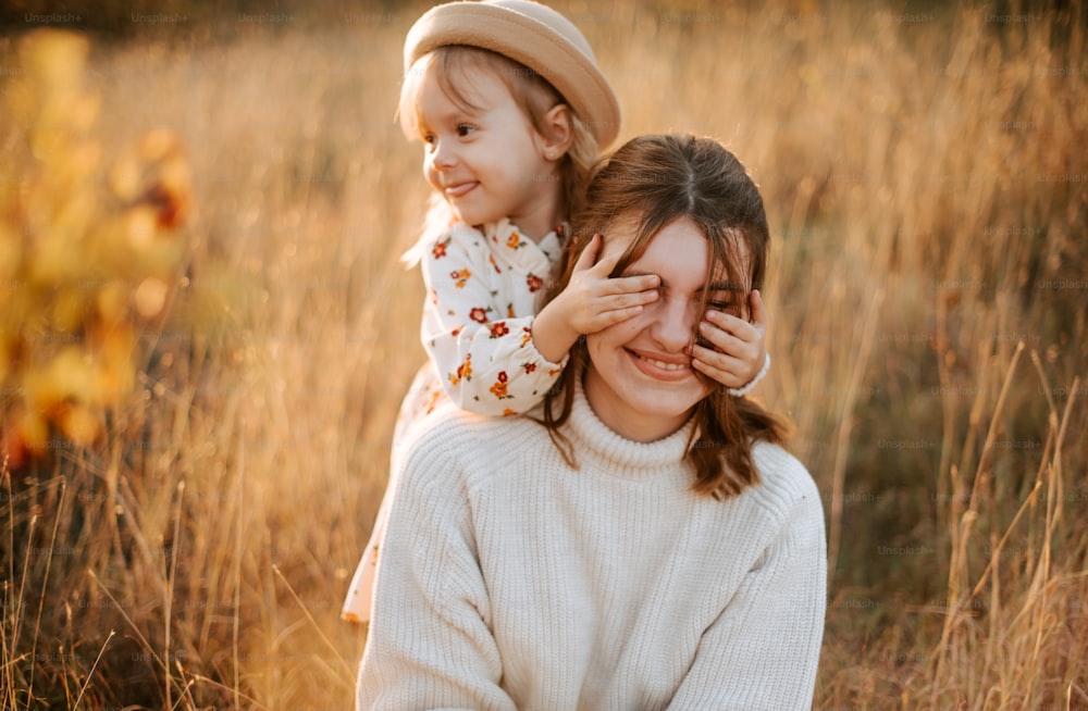 a woman holding a little girl in a field