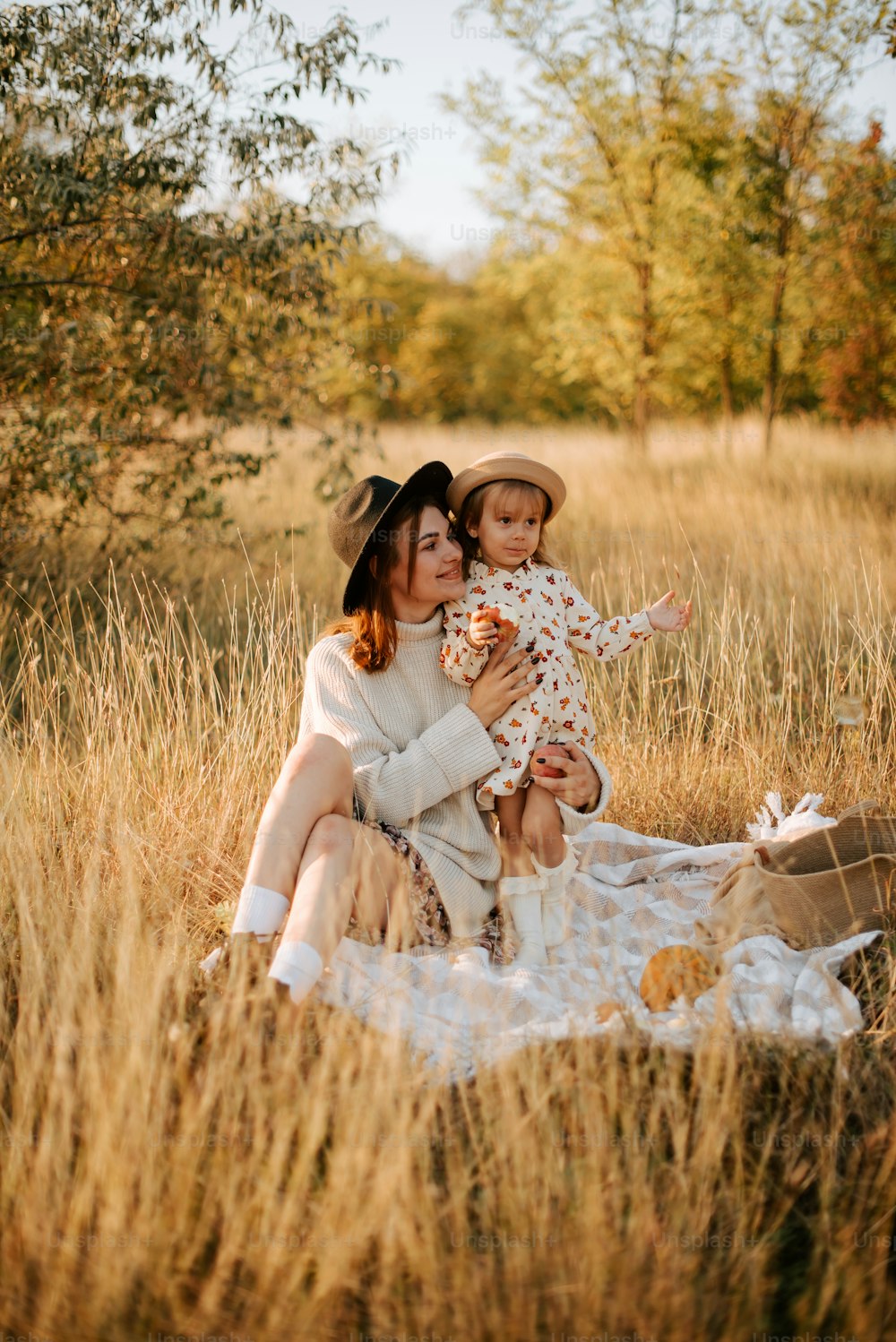 a woman and a child are sitting in a field