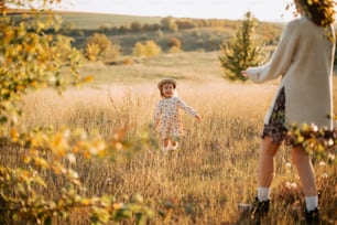 a woman and a little girl are playing in a field